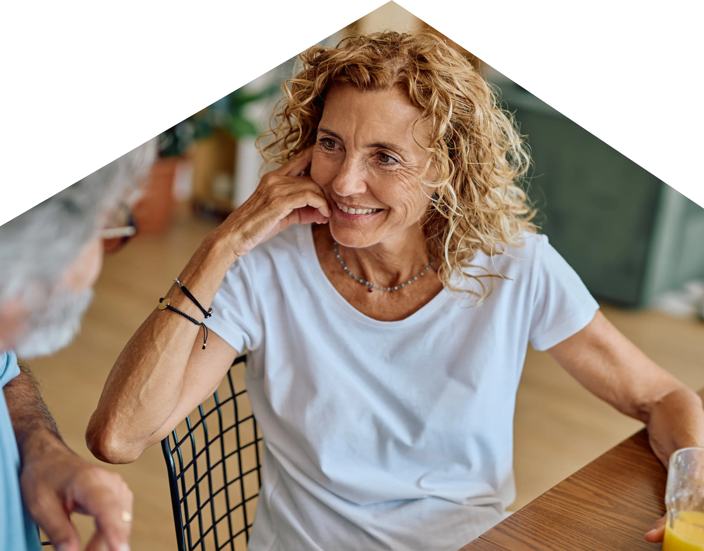 A resident smiling while chatting with a carer at a table
