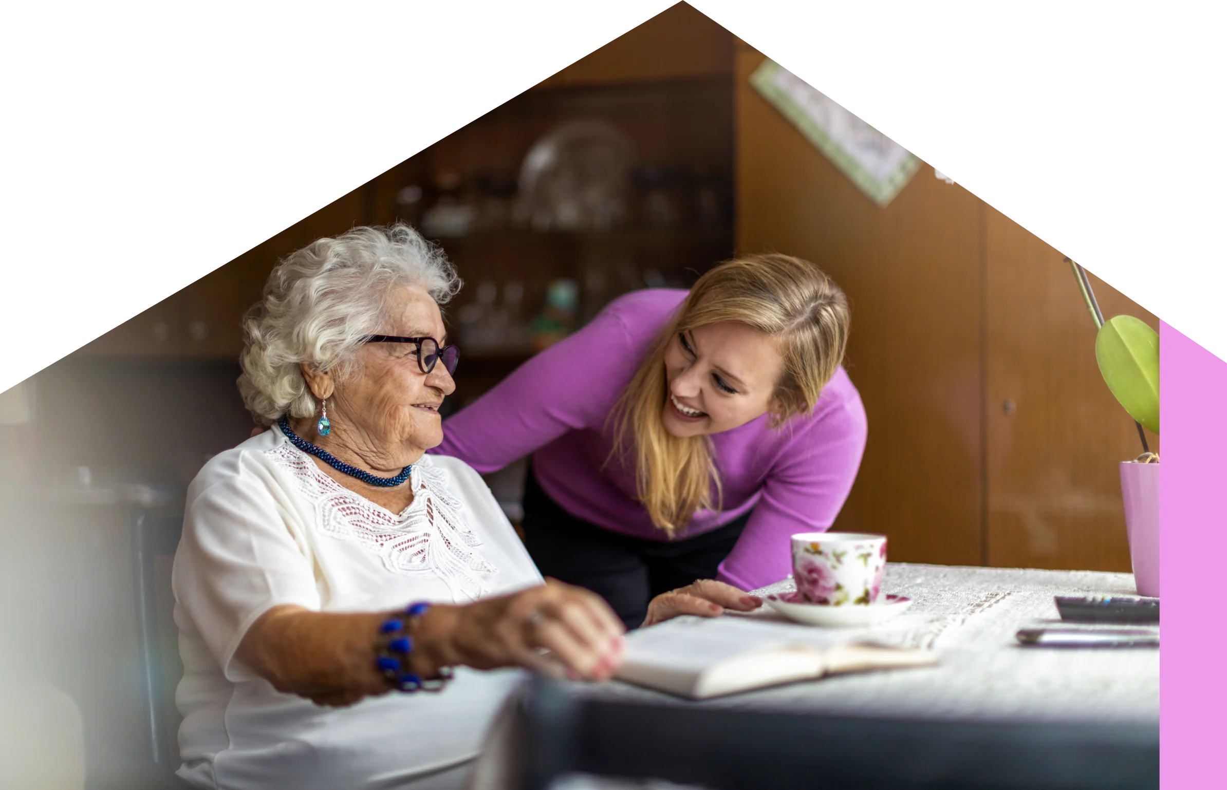 A carer chatting with a resident over a cup of tea at the table