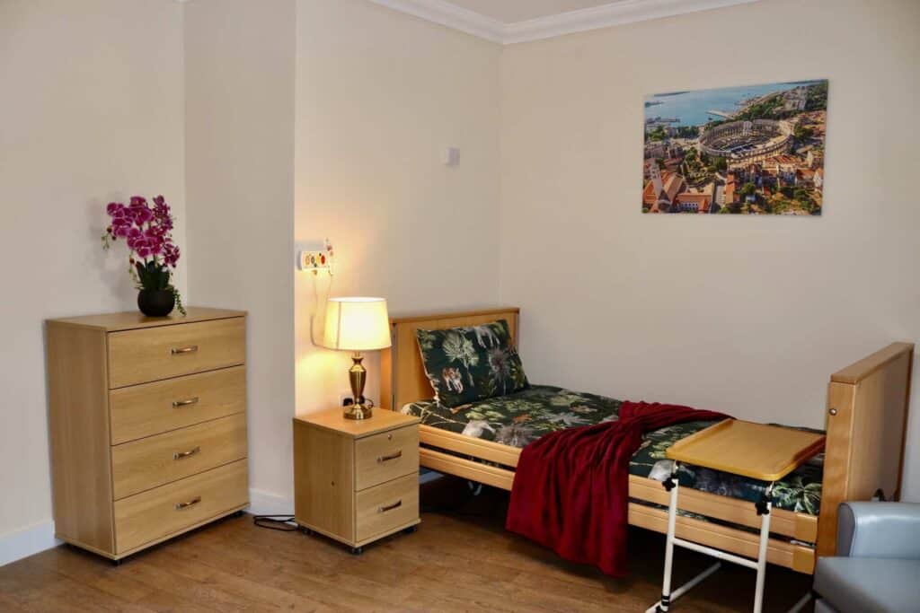 Cozy bedroom with single bed, wooden furniture, and wall art at Lola's House.