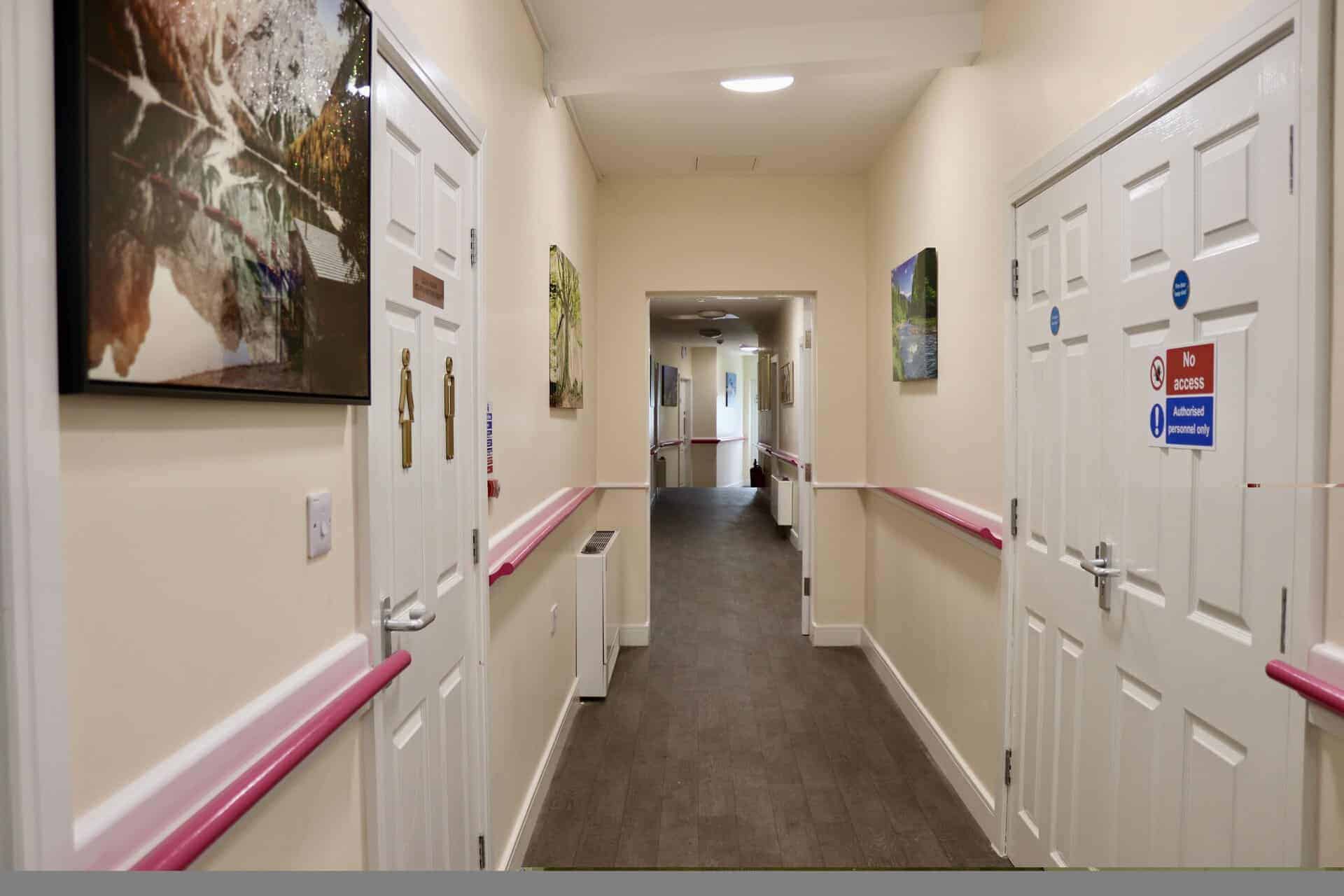 Interior corridor of Lola's House with artwork and safety features.