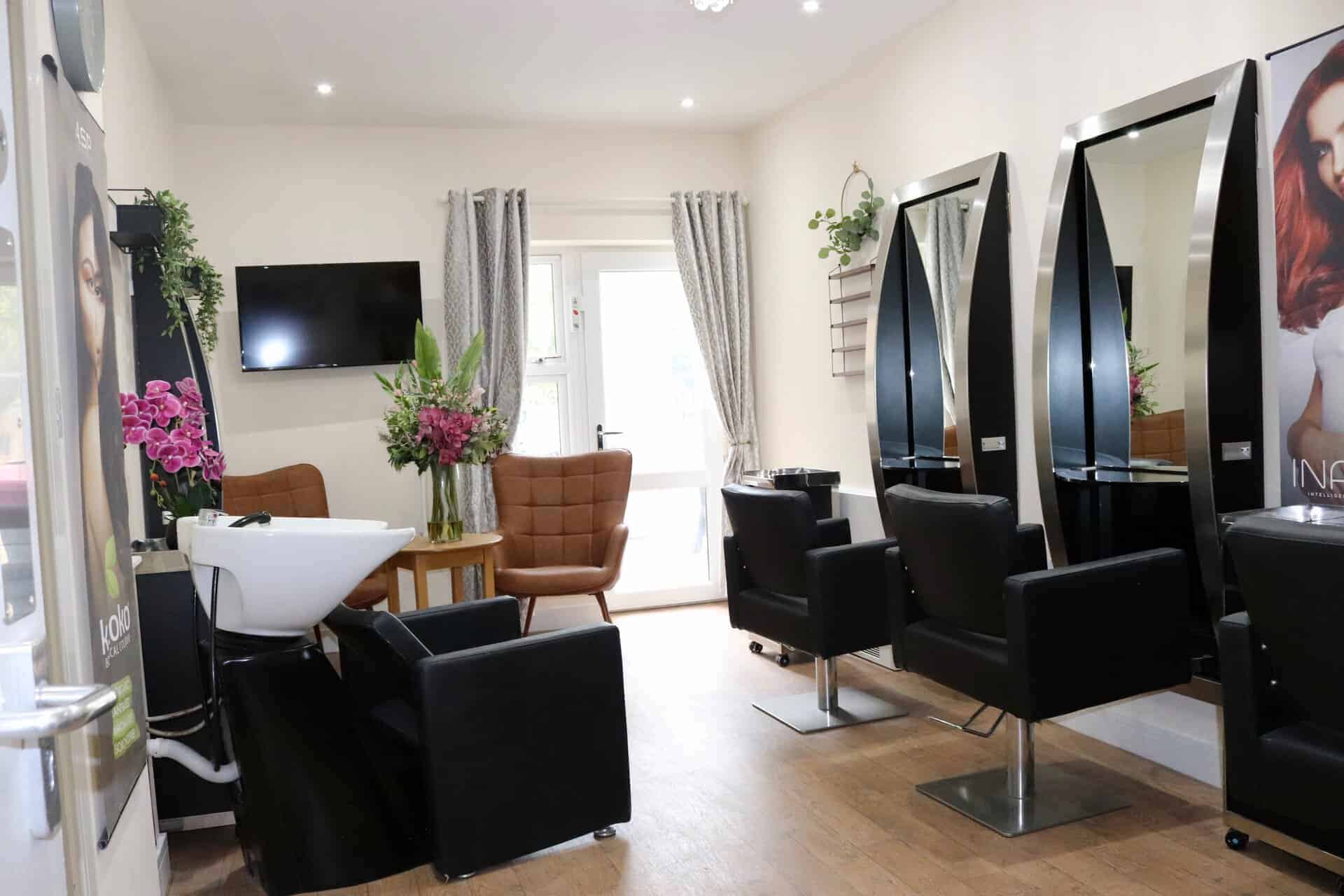Modern hair salon with styling stations, chairs, and a TV in Lola's House.