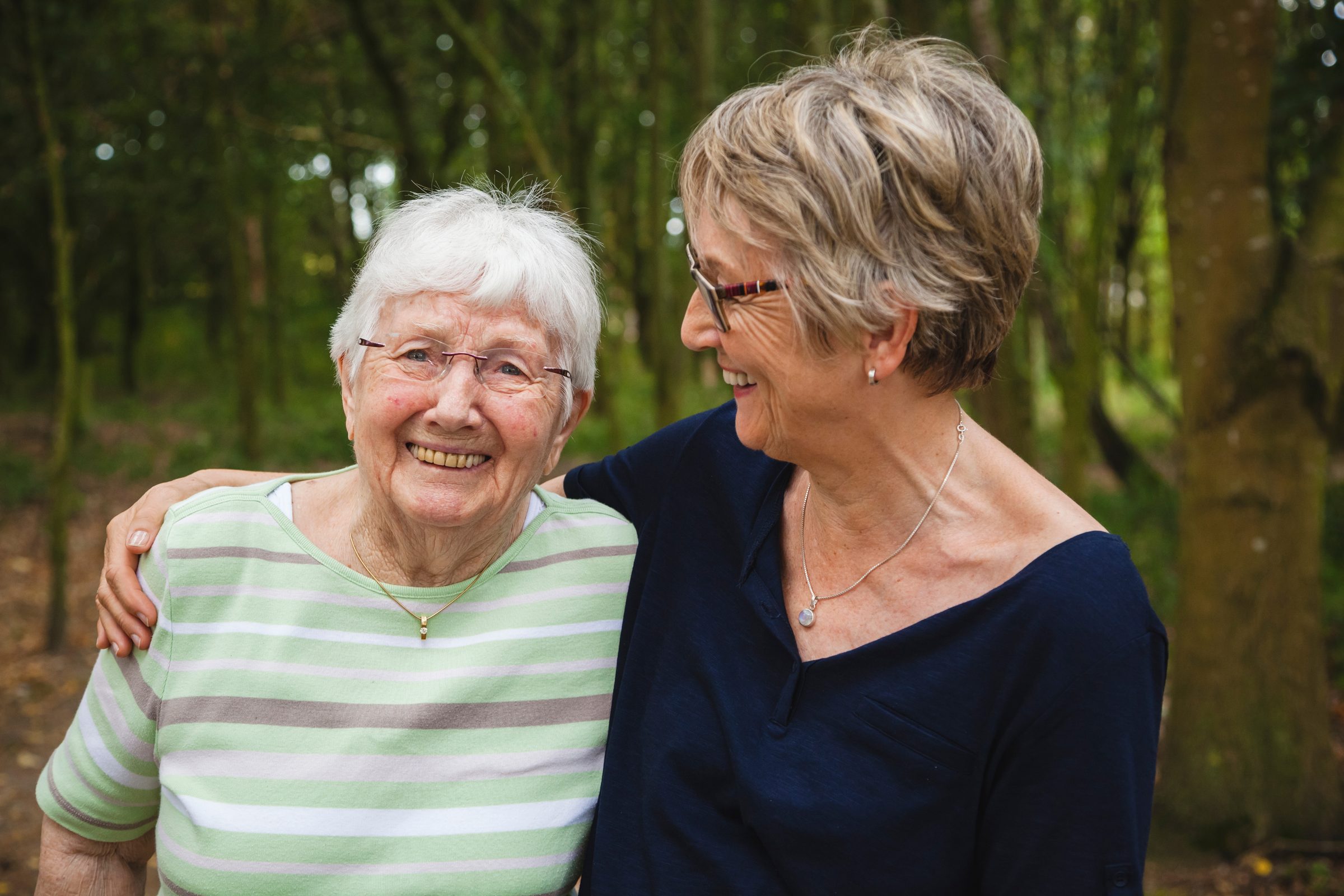 A resident and her daughter smiling together outdoors
